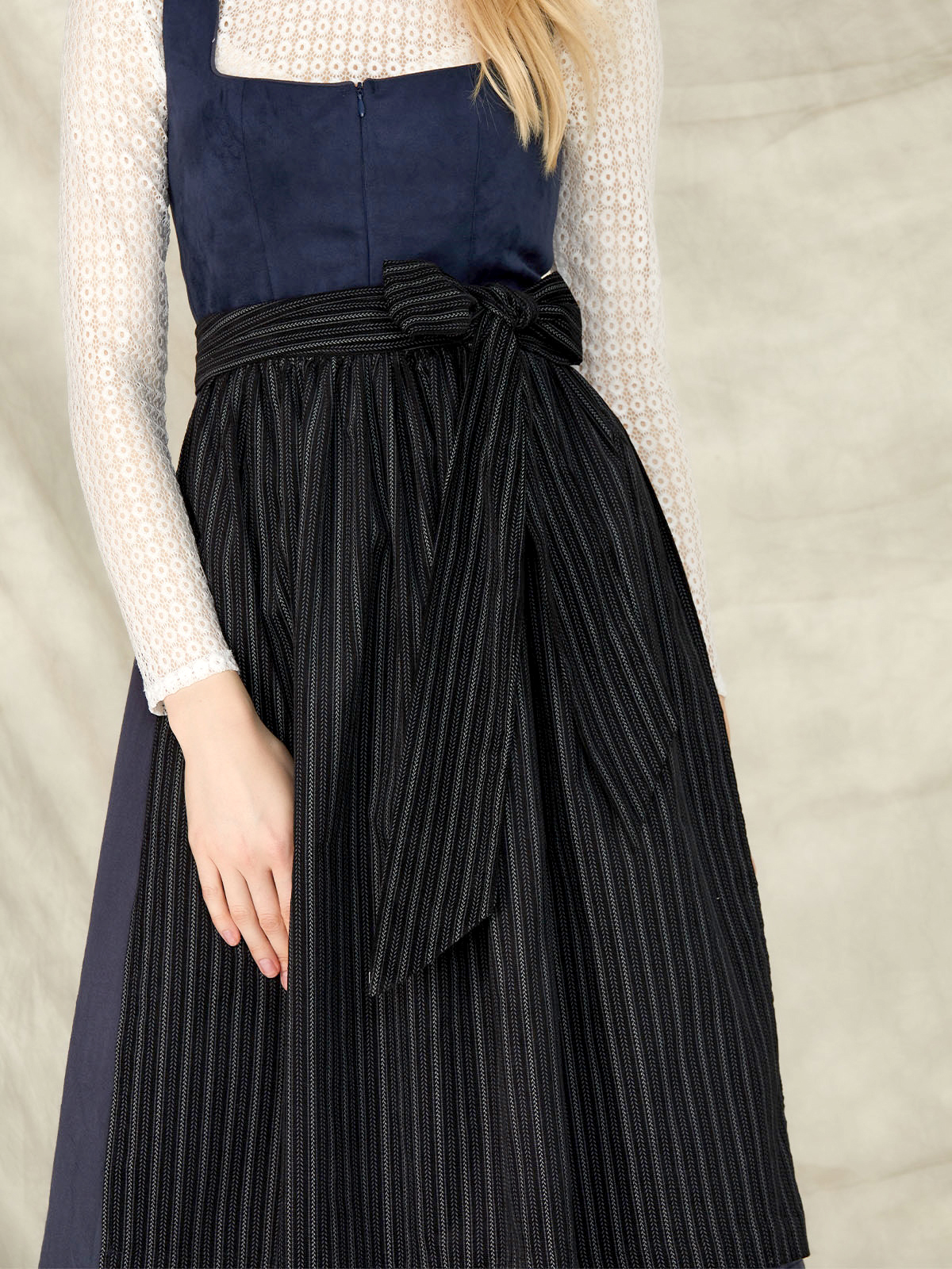 Eine graue Dirndlbluse in Kombination mit einem blauen Dirndl